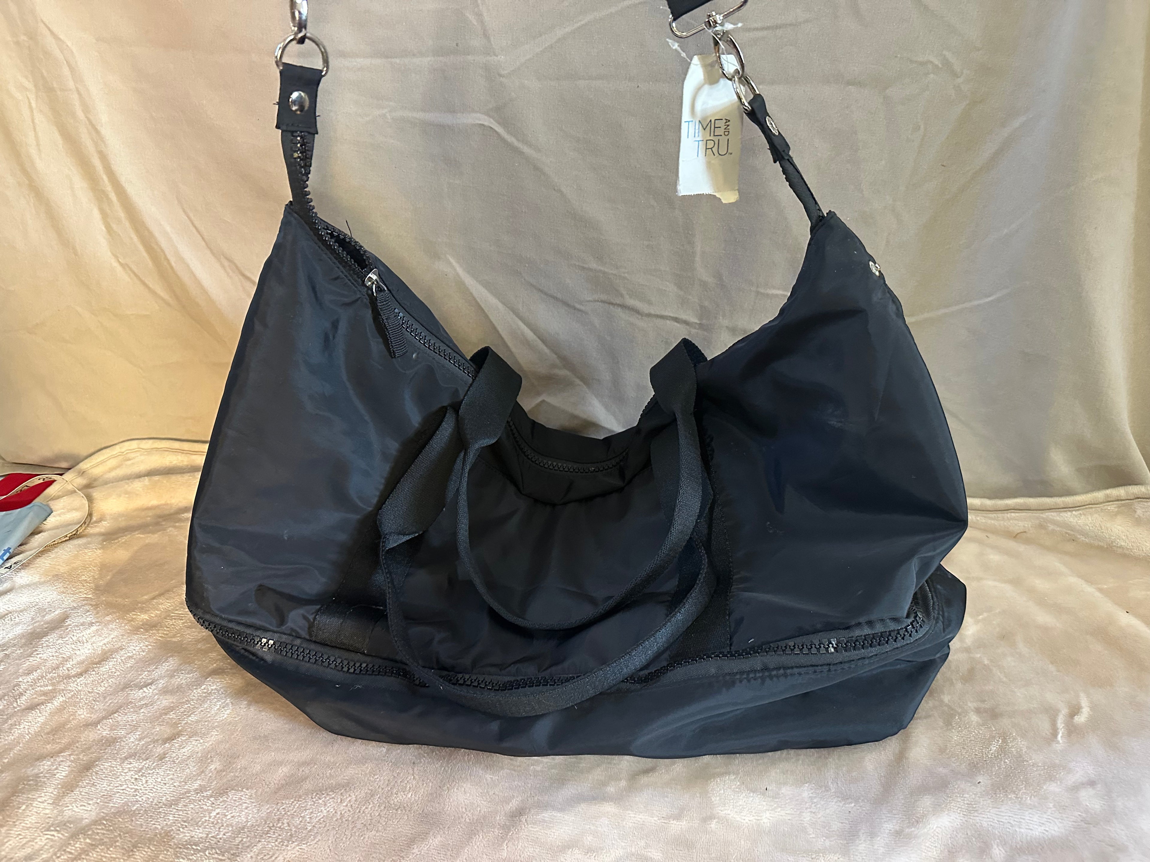 Large Black tote bag with bottom zippered compartment.